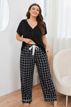 Plus size v-neck top with long sleeve length and black and white plaid pajama pants with drawstring waistband lounge set