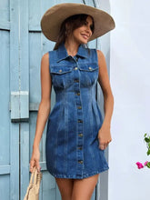 Blue sleeveless denim dress with button front and chest pockets in a pocketed button up sleeveless denim dress style