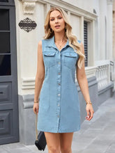 Light blue sleeveless denim dress with button front and chest pockets in a casual pocketed denim dress style