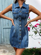 A fitted sleeveless denim dress with collar front button closure and two chest pockets in classic blue denim