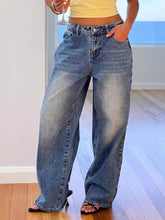Pocketed wide leg jeans in faded medium-wash blue denim with classic stitching and button fly detail