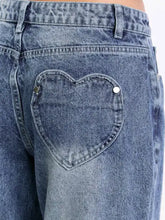 Back side of blue denim wide leg jeans with a heart-shaped back pocket and silver-toned button fastenings