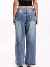 Back view of faded blue wide leg jeans with heart shaped back pockets made of denim material