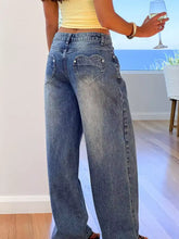 Back view of faded blue wide leg denim jeans with heart-shaped back pockets and subtle distressing