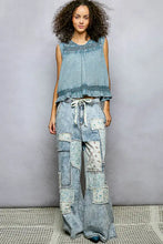 Light-wash denim patchwork pants with floral fabric insets paired with pol button closure cotton blouse back view