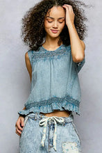 Light blue sleeveless cotton blouse with pol button closure on back embroidered detailing and ruffled hem trim detail