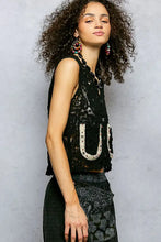Black lace sleeveless cropped crochet vest with white embroidered u-shaped details and scalloped edge pol button design