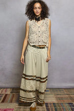 Beige scalloped edge pol button cropped crochet vest with intricate lace and black button accents