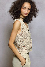 Cream-colored cropped crochet vest with scalloped edge featuring delicate floral patterns and pol button detailing