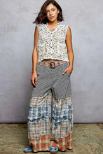 Patchwork wide-leg pants with striped and plaid fabric and frayed hems paired with pol button down cropped crochet vest with scalloped edge