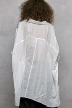 White loose fitting blouse with subtle vertical seam detailing and relaxed collar for embroidered floral hem shirt with high low hem