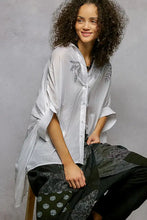 White embroidered floral button down shirt with flowing sleeves and high low hem detailing