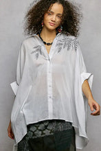 White embroidered floral button-down shirt with leaf motifs and a high low hem design from pol