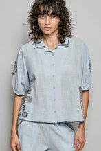 Light blue lightweight woven linen POL button down short sleeve shirt with embroidered floral and beaded trim details