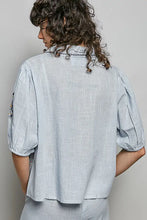 Light blue lightweight woven blouse with puffed sleeves and embroidered floral detail along the collar
