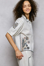 White linen embroidered floral short sleeve shirt with black beige and gold thread embroidery on collar sleeves and side seam