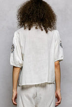 White linen embroidered floral short sleeve blouse with black floral embroidery and subtle textured weave