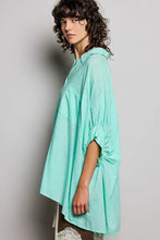 A loose-fitting mint green linen POL button down shirt with collar and half dolman sleeves gathered at cuffs