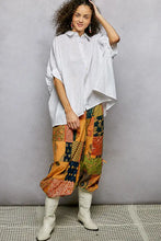 Vibrant patchwork pant in orange green and navy patterns paired with a half dolman sleeve dolman sleeve shirt