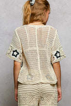 Cream crochet cardigan with POL button front and black star motifs on sleeves