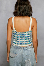 A teal and white crochet cami with scalloped edge and thin off-white straps featuring a grid pattern