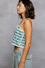 A blue and cream crocheted cropped cami with geometric pattern and scalloped edge detail