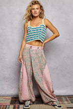 A woman wears a blue and white checkered crochet cami with thin straps and scalloped edge detailing
