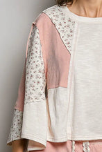A cream and pink round neck textured slub knit top with floral prints and ribbed panels in patchwork style