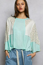 Soft mint green and white textured slub knit round neck top with floral embroidery on the sleeves and patchwork design