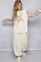 Cream-colored star patch thermal top with sequin and bead embellishment on shoulder seam and floral long sleeve length