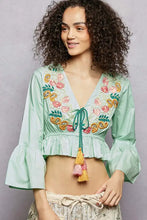 Mint green floral embroidered cropped blouse with paisley embroidery, bell sleeves, and tassel detail at neckline