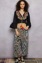 Black floral embroidered cropped blouse featuring vibrant red yellow and gold embroidery at the neckline