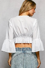 White cropped blouse with bell sleeves and ruffled hem featuring pol floral embroidered design