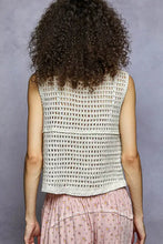 A cream-colored sleeveless crocheted pol floral embroidered v neck vest with textured pattern and frayed hem