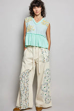 A light blue pol floral patch sleeveless top with raw edge detail floral embroidery on shoulders and ruffled hem