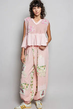 Pink patchwork pants featuring floral and embroidered fabric panels paired with a floral patch ruffled sleeveless top