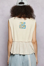 Back view of cream sleeveless top with floral patch ruffled peplum hem and raw edge detail in textured ribbed fabric