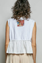 Back view of white sleeveless top featuring a colorful pol floral patch with raw edge detail and textured fabric
