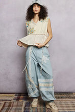 Light blue wide-leg pants with lace trim and star appliqués paired with floral patch ruffled sleeveless top