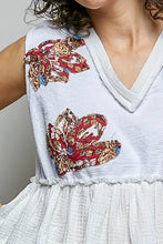 White sleeveless pol floral patch top with raw edge detail and vibrant red gold blue floral patch appliqués on shoulders