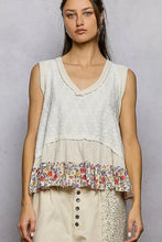 A layered off-white pol floral print sleeveless top with a v neck and floral ruffle trim neck textured tank
