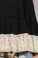 A black lace pol floral print v neck textured tank with a layered ruffled hem and delicate pastel floral print