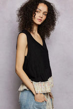 Black sleeveless pol floral print v neck textured tank with a delicate floral pattern and ruffled hem