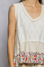 A cream-colored sleeveless pol floral print v neck textured tank with a textured bodice and ruffled floral hem