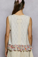 A cream cream-colored sleeveless pol floral print v neck textured tank with floral ruffle trim and patch detail on the back