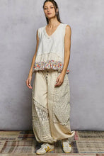 The model wears a sleeveless off-white pol floral print v neck textured tank with lace and floral ruffle hem detailing