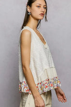 A soft off-white pol floral print v neck textured tank with sleeveless design and colorful floral ruffle hem trim