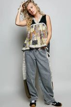 A pol floral sheer tank with patchwork floral design lace trim and a black v-neckline for elegant wear
