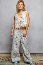White crochet sleeveless vest with diamond pattern and scalloped edge fringe trim featuring a frayed hem