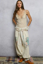 Beige patchwork harem pants with floral and map fabric panels, ruffled waistband, gathered cuffs paired with pol lace neck ribbed cami